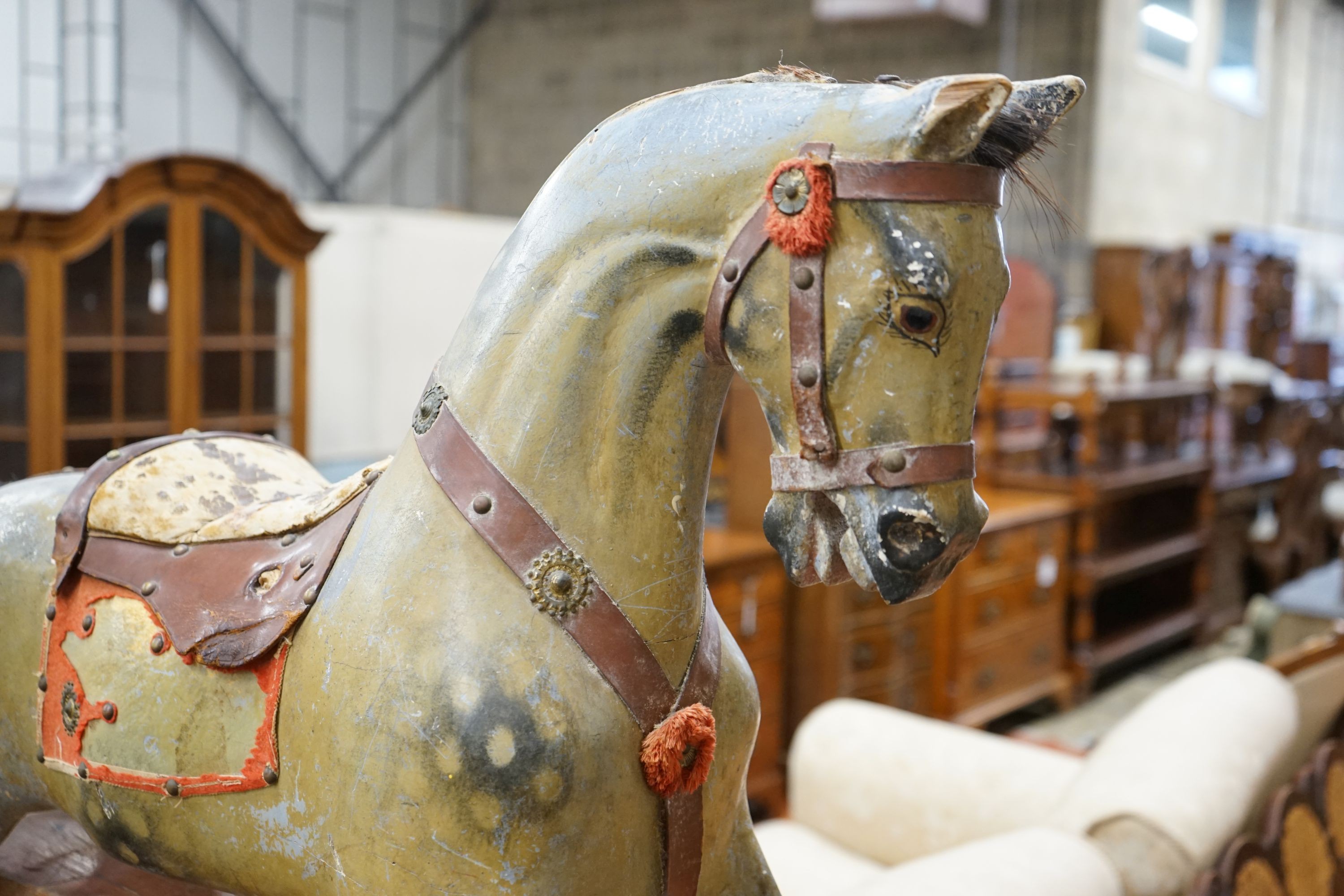 An Edwardian carved wood and dapple painted rocking horse, raised in a trestle frame, length 127cm, height 95cm